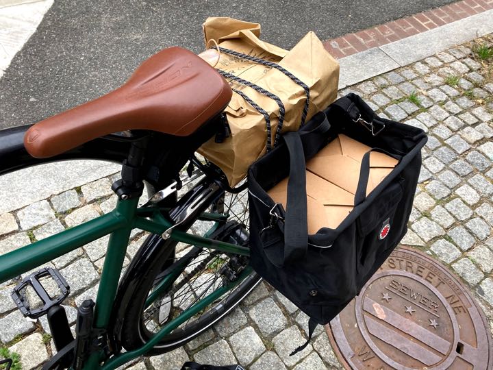 author's bike loaded up with takeout boxes, in front of DC manhole cover