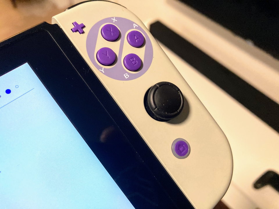 Close-up of buttons on modded Nintendo Switch, showing purple buttons and gray joy-con case